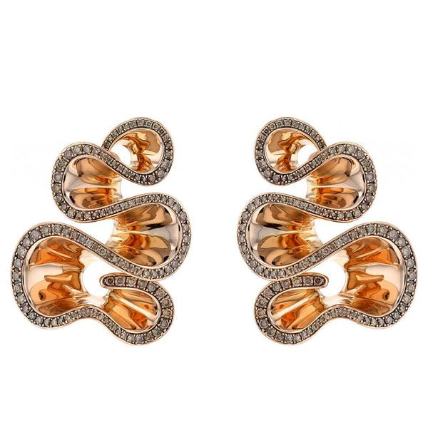 An exquisite de Grisogono earring rests on a modern desk during a professional appraisal.