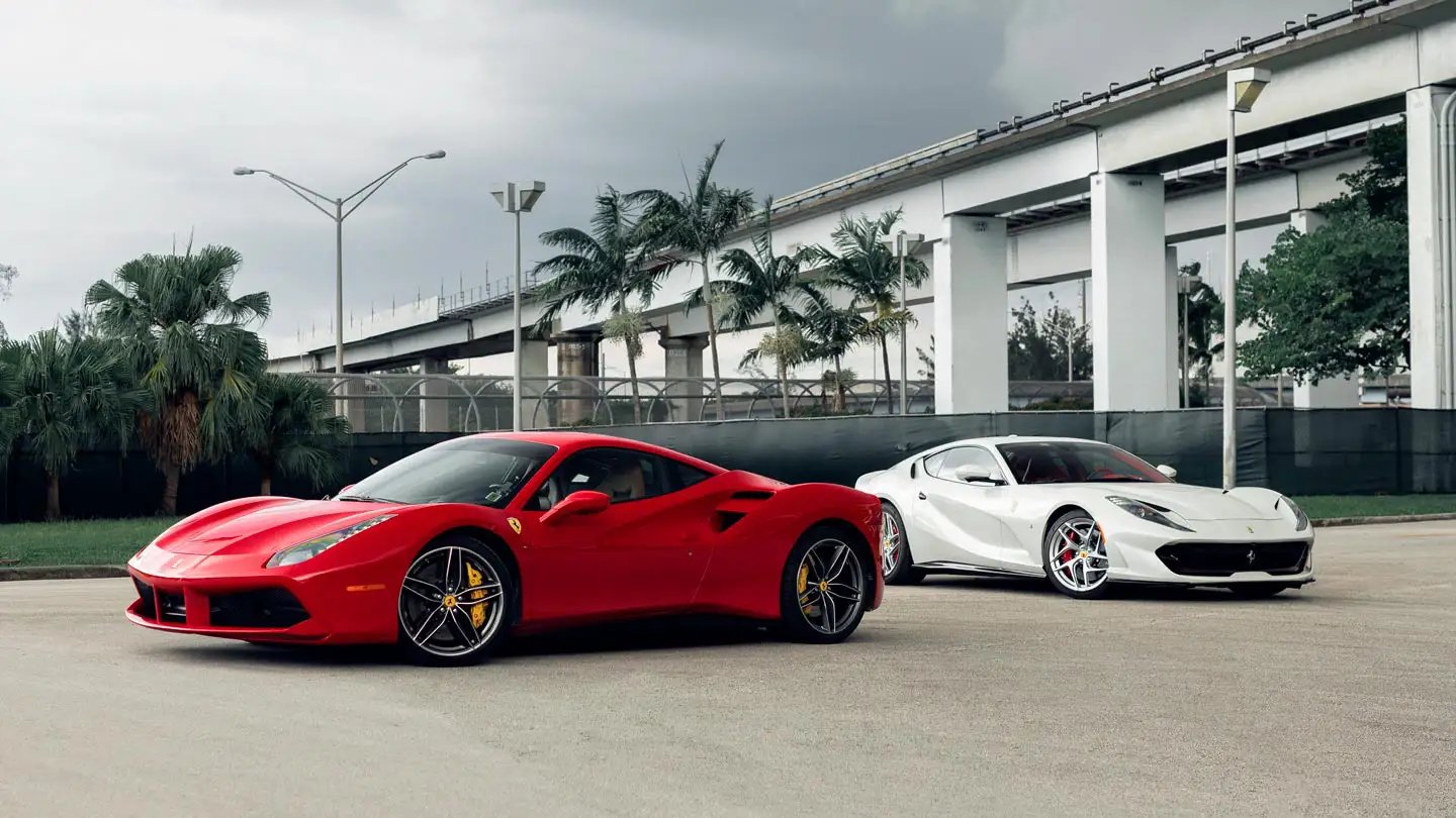 A luxury red Ferrari sports car parked in front of a modern villa.