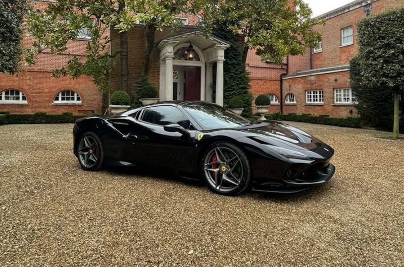 A luxury red Ferrari parked on a coastal road for a daily rental experience.