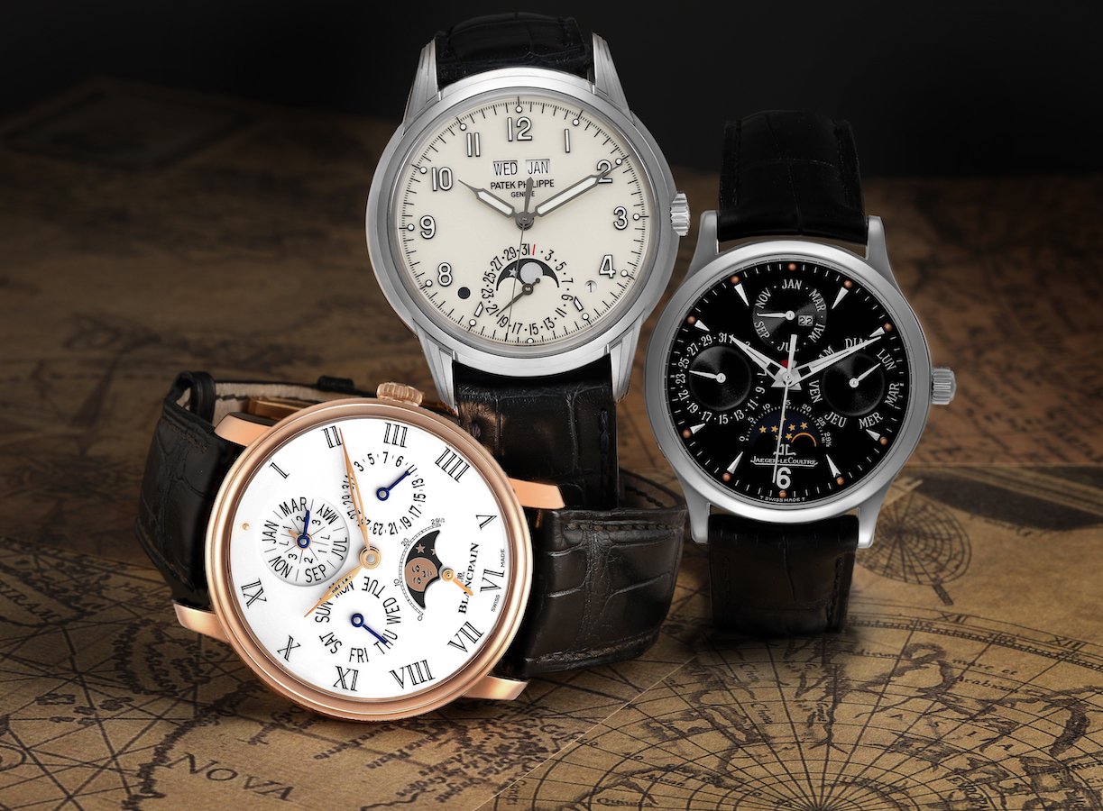 A luxury Patek Philippe watch sitting on a desk with writing materials.