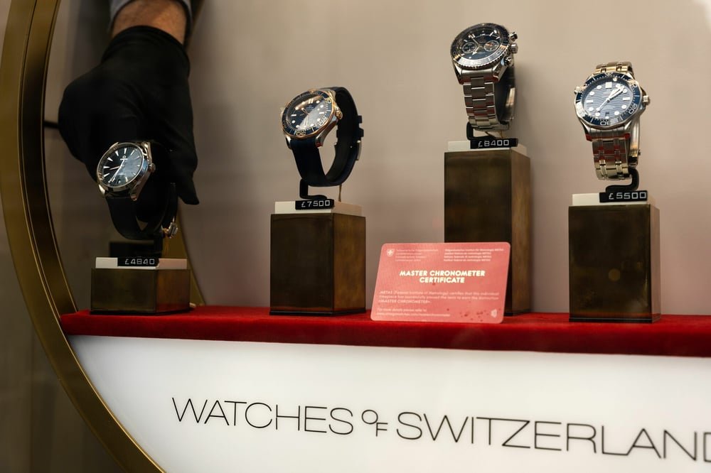 A luxury watch displayed neatly on a desk with a notebook and pen.