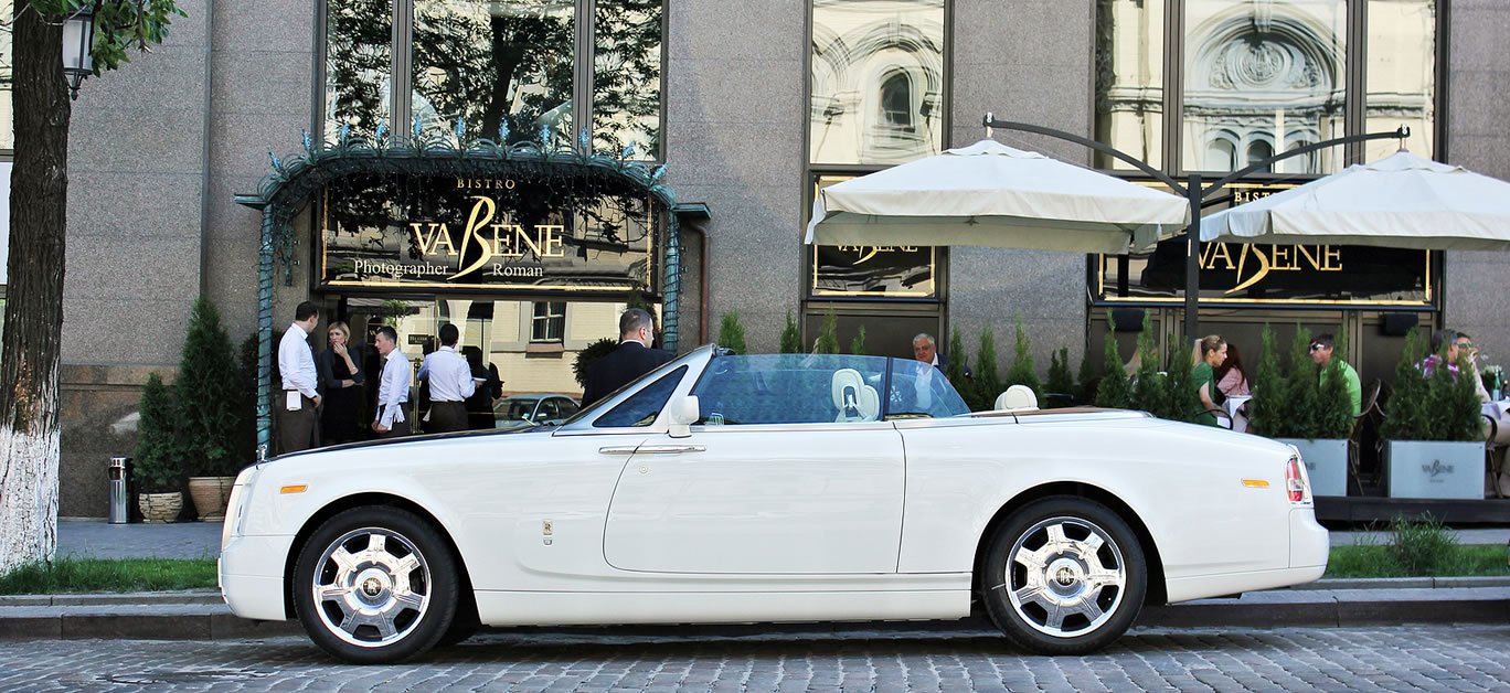 A craftsperson carefully hand-stitching a premium leather interior for a luxury Rolls-Royce vehicle.