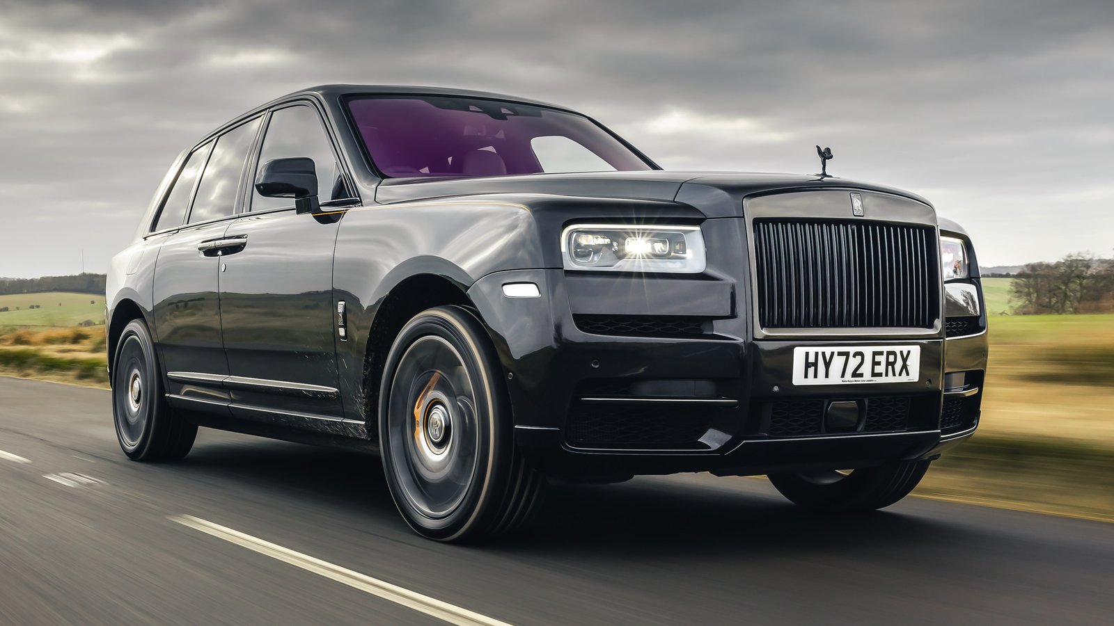 A luxury Rolls-Royce Phantom parked elegantly in front of a historic British estate.